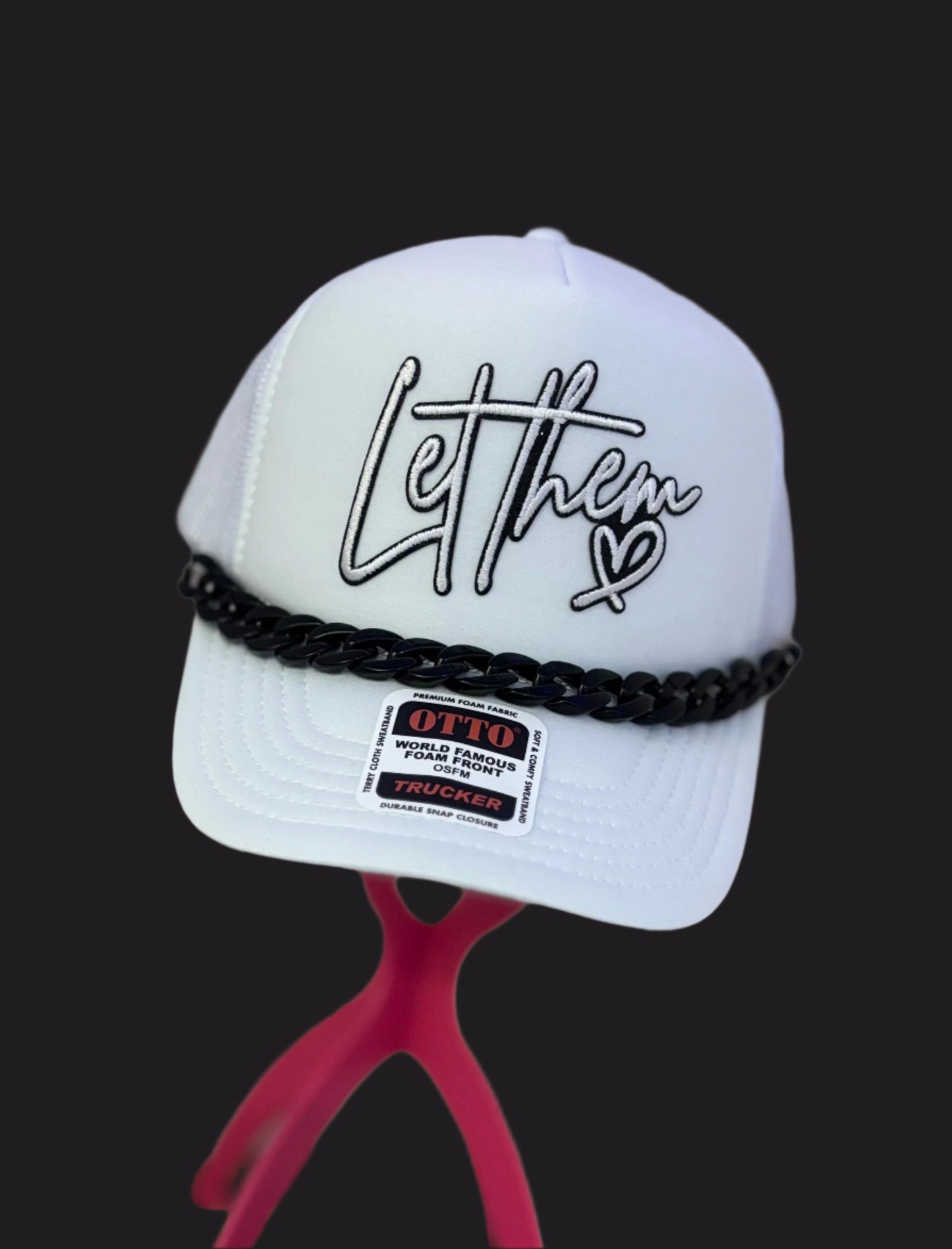 White cap with black text and design on a mannequin head against a neutral background